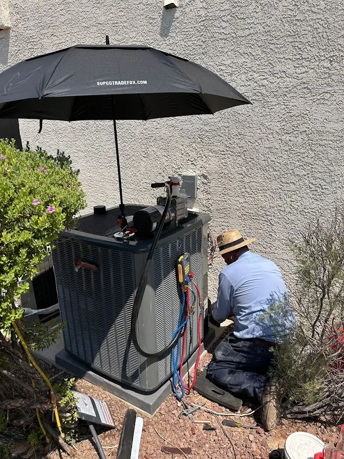 HVAC technician performing outdoor AC maintenance in Avenal